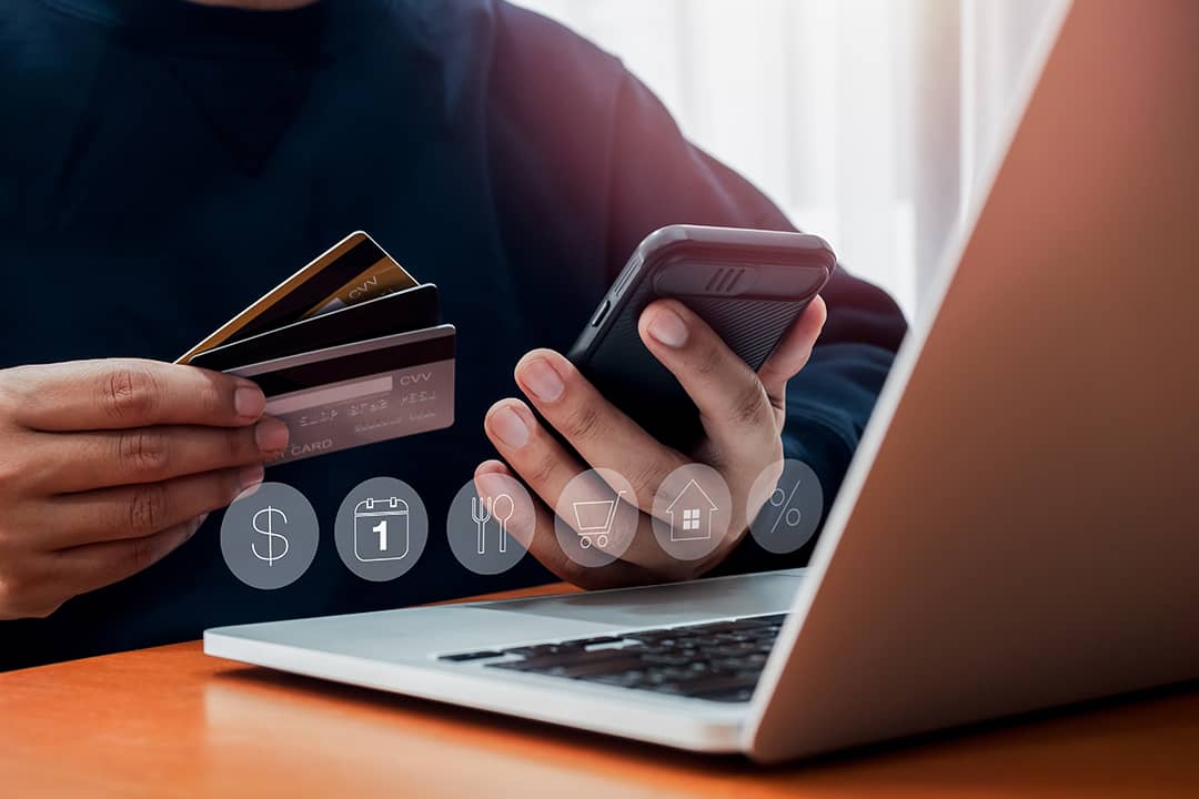 A person holding a few card and his smartphone during a budget review and debt consolidation.